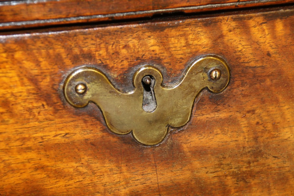 An 18th-century English walnut bachelors writing chest featuring four graduated drawers, brass plate handles, bracket feet, and side carrying handles. View VIII