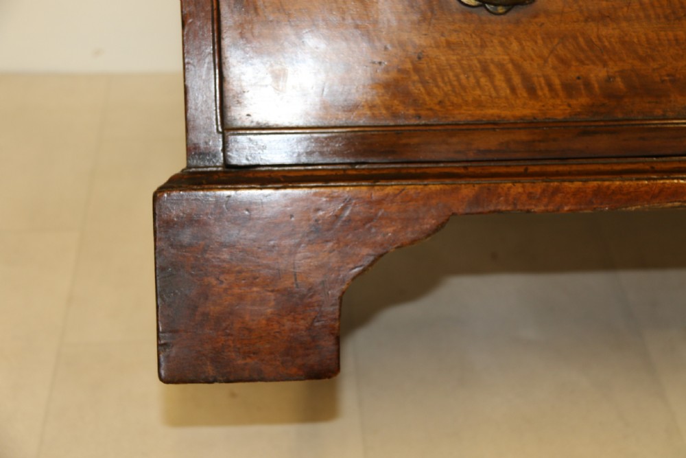 An 18th-century English walnut bachelors writing chest featuring four graduated drawers, brass plate handles, bracket feet, and side carrying handles. View X