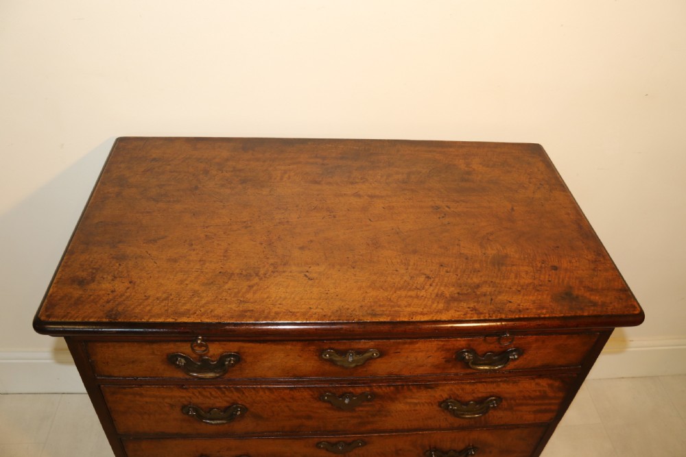 An 18th-century English walnut bachelors writing chest featuring four graduated drawers, brass plate handles, bracket feet, and side carrying handles. View XII