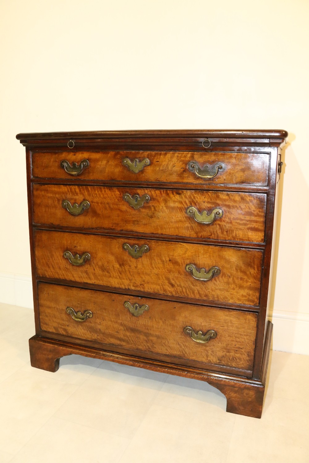 An 18th-century English walnut bachelors writing chest featuring four graduated drawers, brass plate handles, bracket feet, and side carrying handles. View XXIII