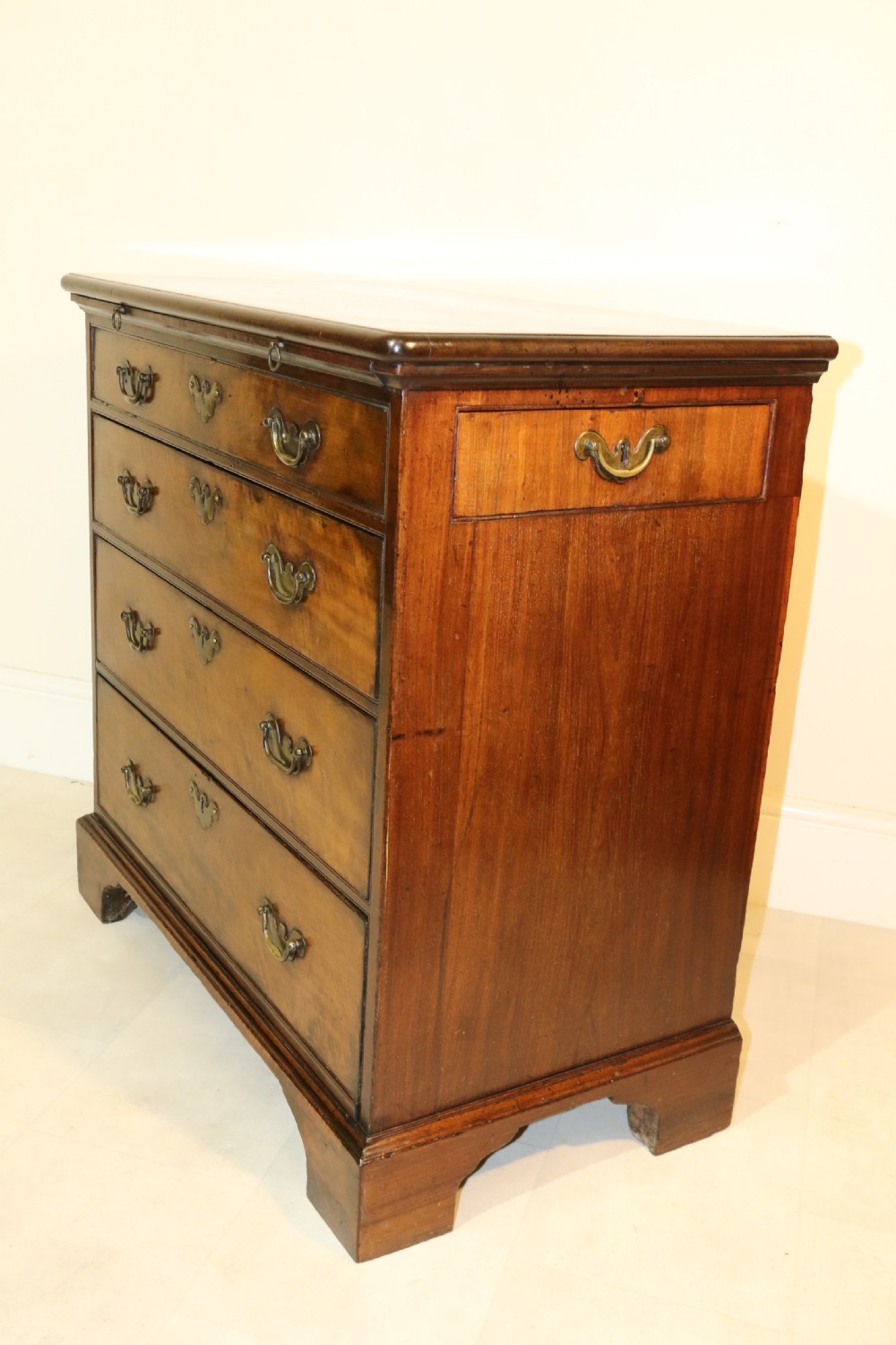 An 18th-century English walnut bachelors writing chest featuring four graduated drawers, brass plate handles, bracket feet, and side carrying handles. View XXIV
