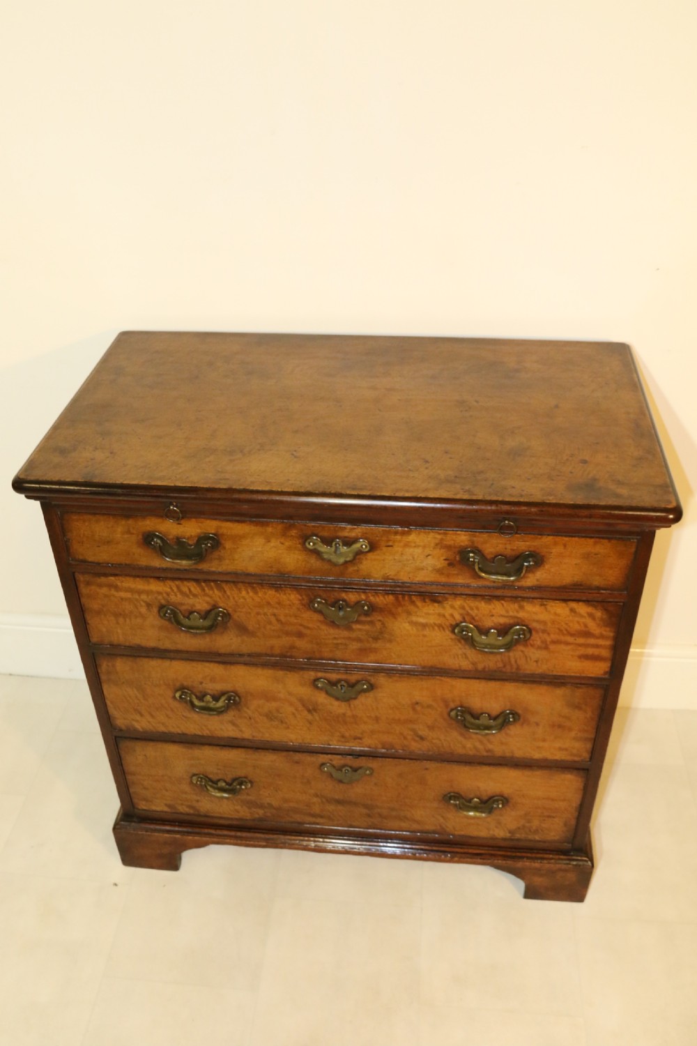 An 18th-century English walnut bachelors writing chest featuring four graduated drawers, brass plate handles, bracket feet, and side carrying handles. View XXVI