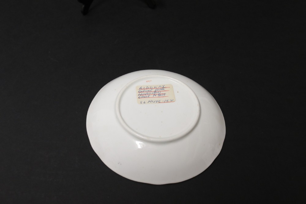 An early 19th-century English porcelain cabinet cup and saucer decorated with magenta borders, gold scrollwork gilding, and hand-painted miniature landscape vignettes. View VIII