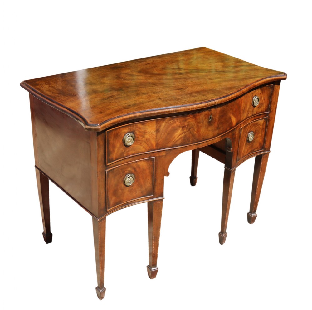 A Georgian serpentine fronted side table with writing and dressing fitment