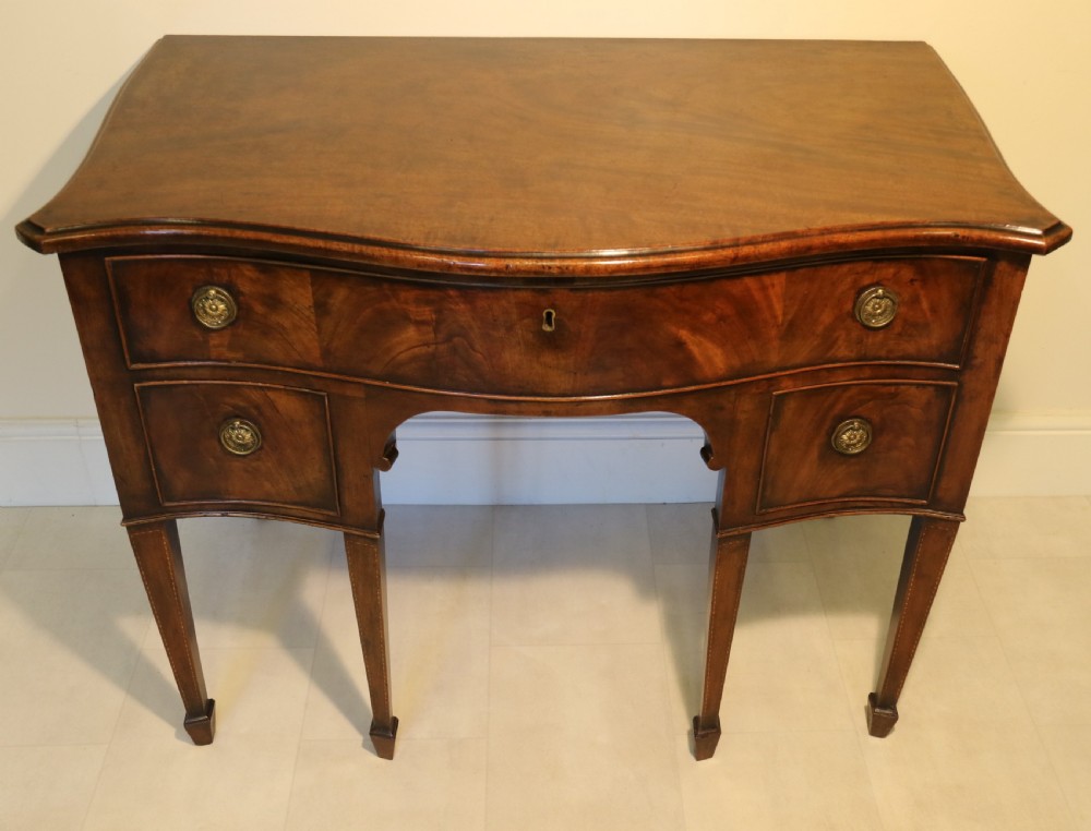 A Georgian serpentine fronted side table with writing and dressing fitment View II