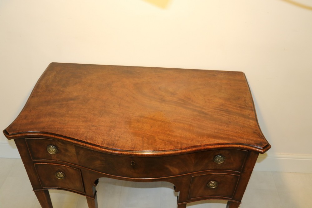 A Georgian serpentine fronted side table with writing and dressing fitment View VI