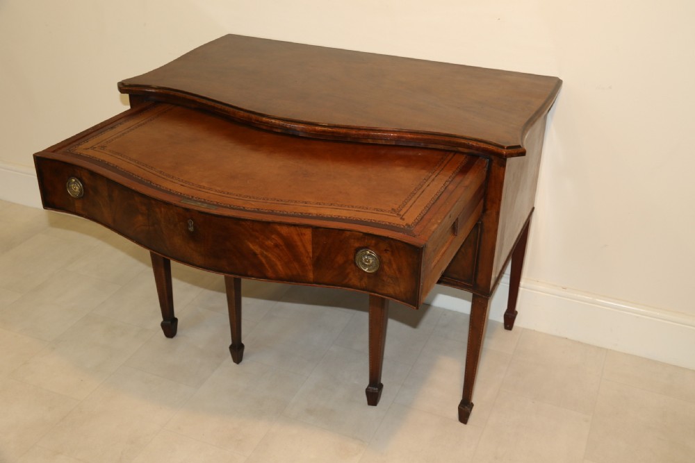 A Georgian serpentine fronted side table with writing and dressing fitment View XIX