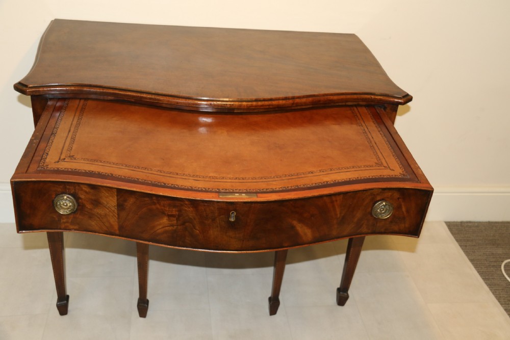 A Georgian serpentine fronted side table with writing and dressing fitment View XX