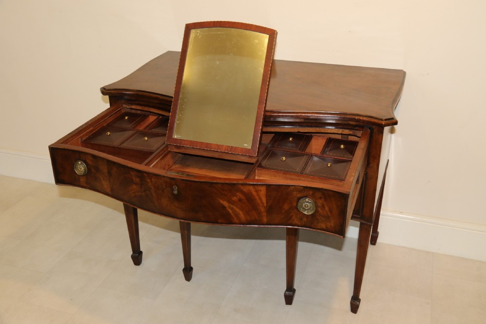 A Georgian serpentine fronted side table with writing and dressing fitment View XXV