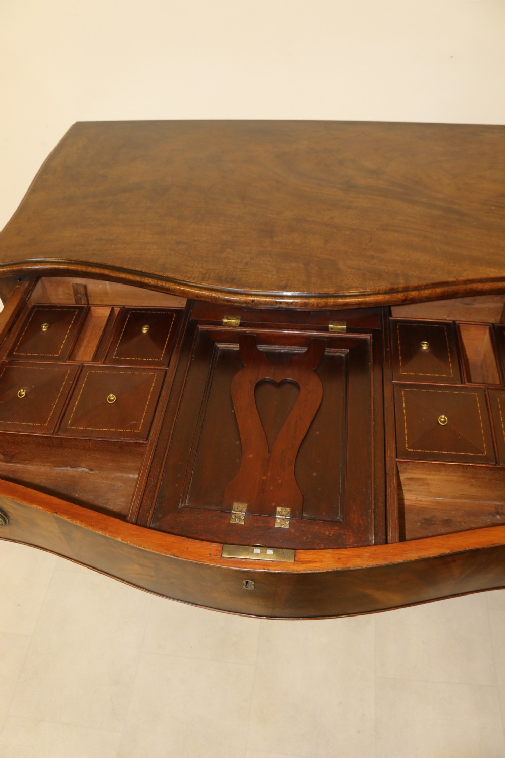 A Georgian serpentine fronted side table with writing and dressing fitment View XXIX