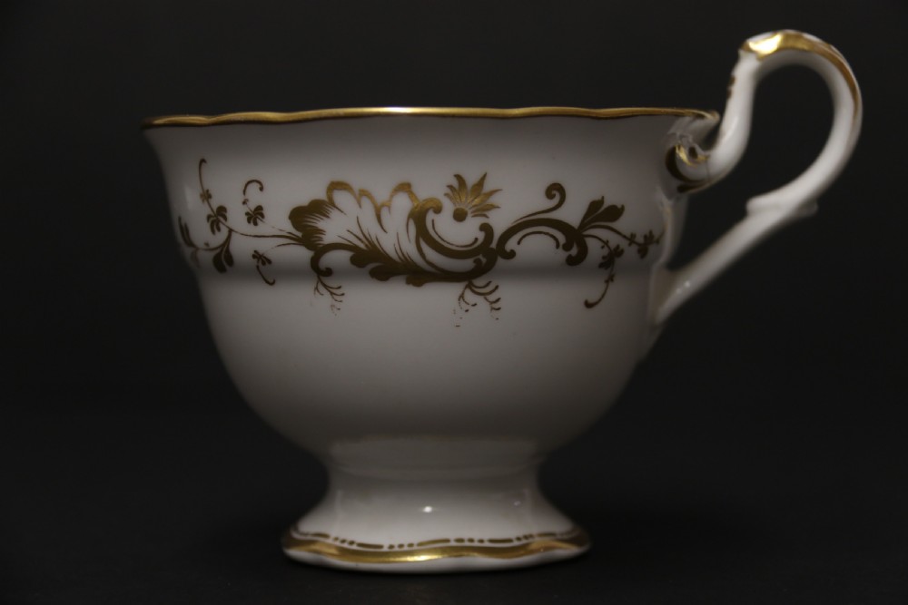 An early nineteenth-century Davenport porcelain cabinet trio comprising a teacup, coffee cup, and matching saucer decorated with hand-painted botanical flowers and gilded scrolling borders. View VIII
