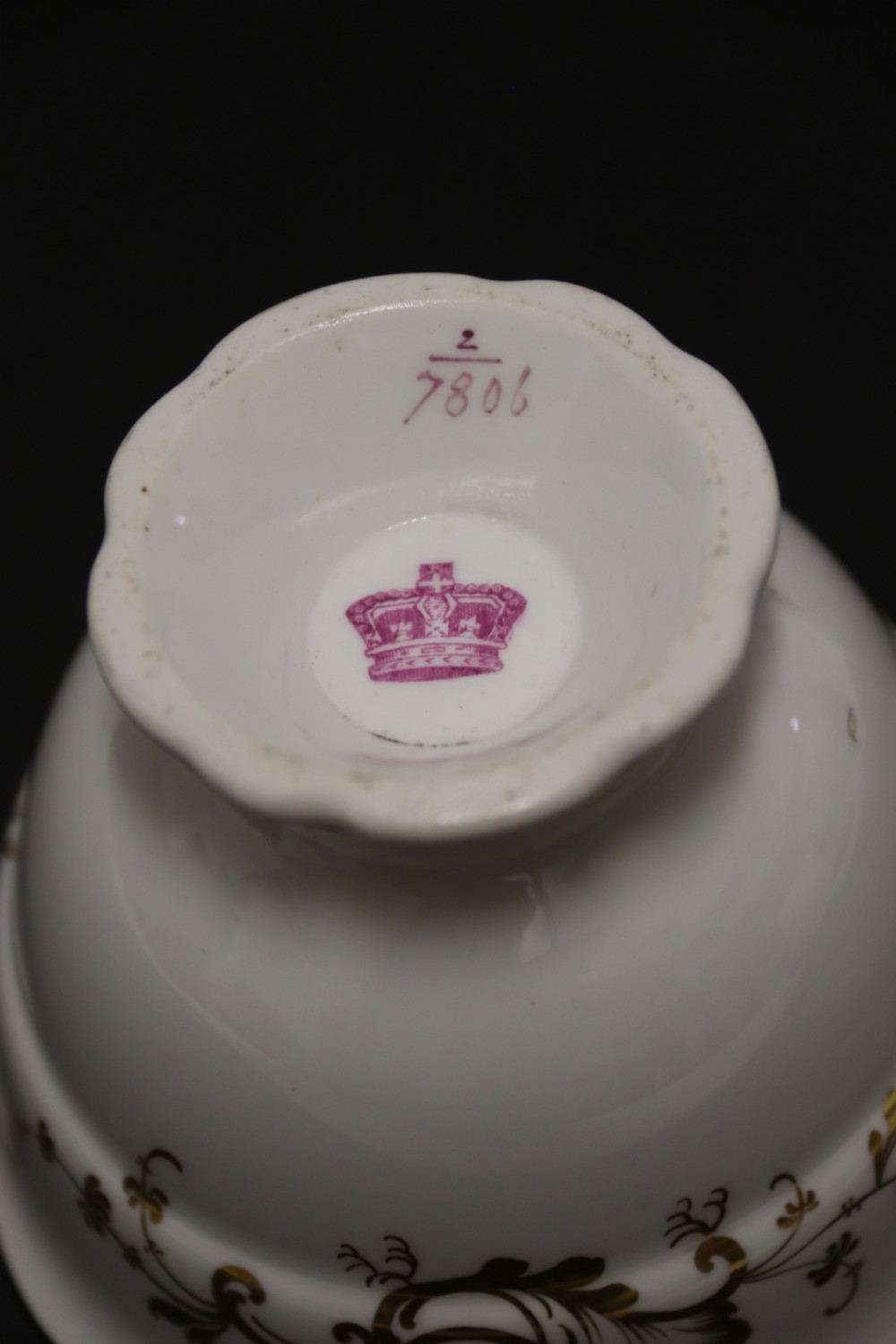 An early nineteenth-century Davenport porcelain cabinet trio comprising a teacup, coffee cup, and matching saucer decorated with hand-painted botanical flowers and gilded scrolling borders. View IX