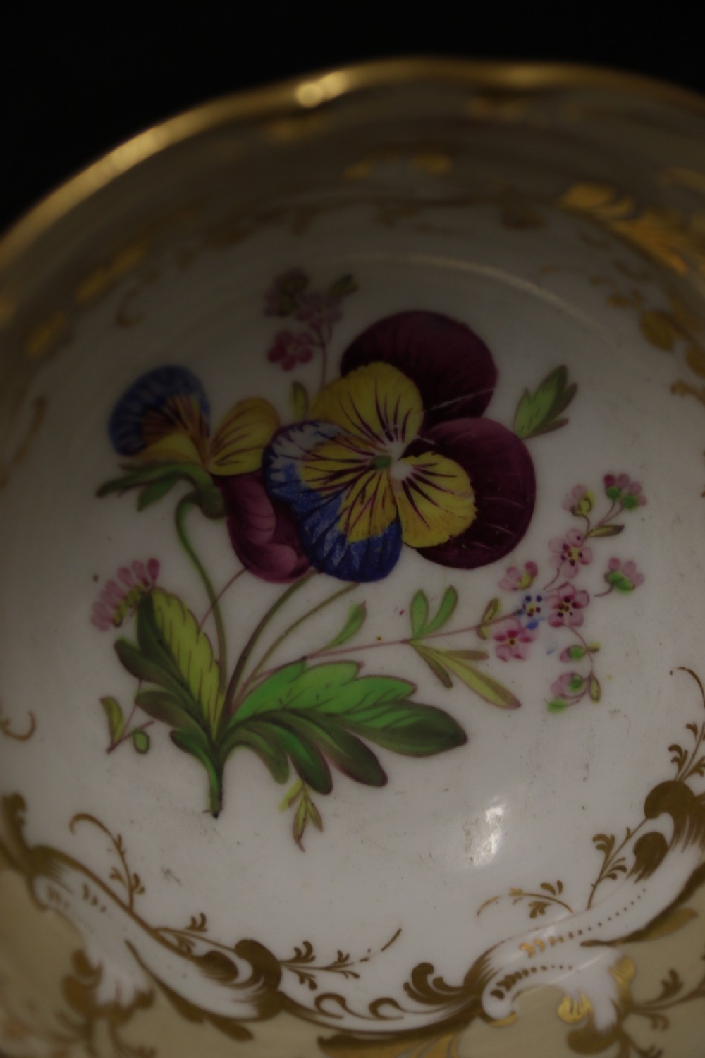 An early nineteenth-century Davenport porcelain cabinet trio comprising a teacup, coffee cup, and matching saucer decorated with hand-painted botanical flowers and gilded scrolling borders. View XI