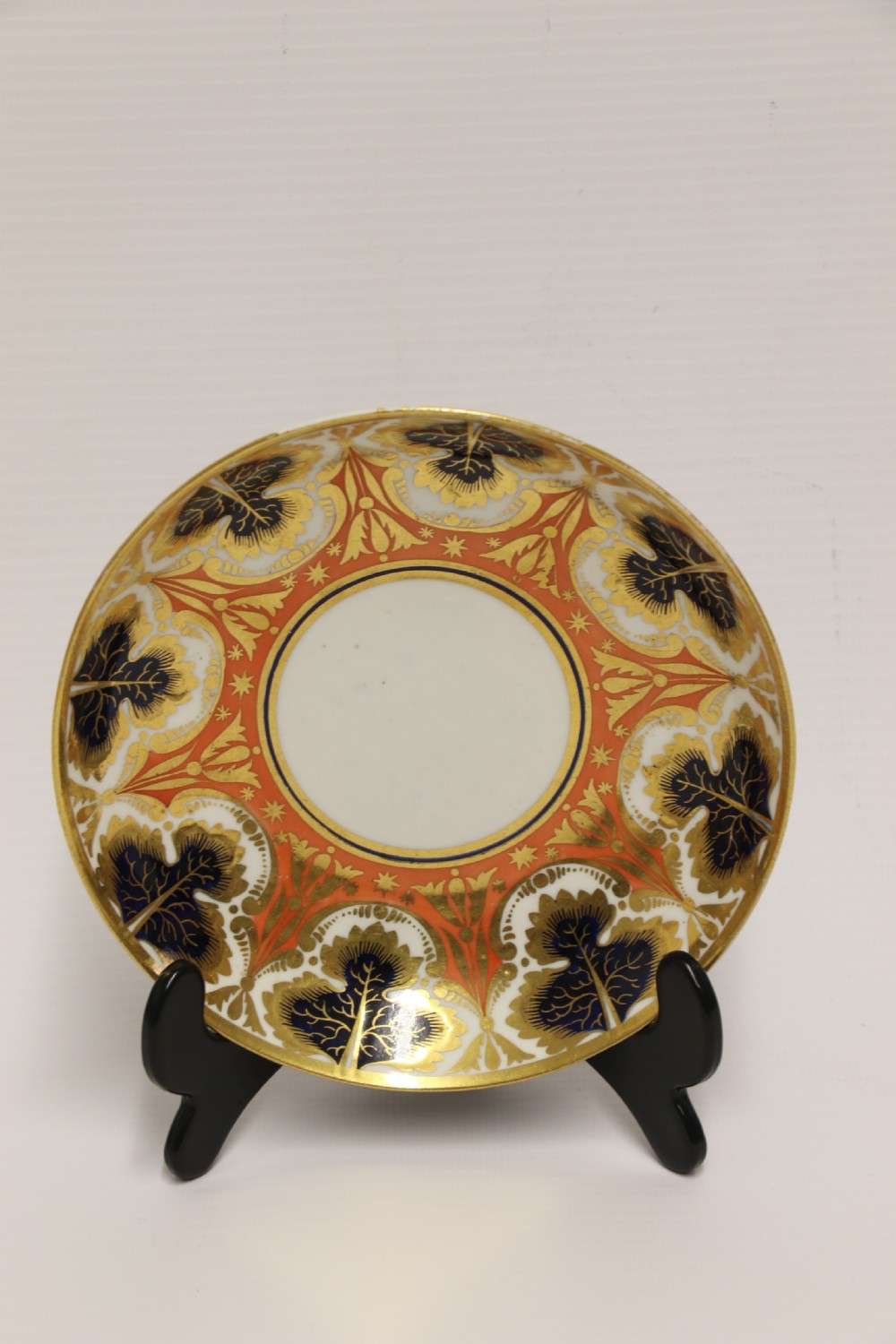 An early nineteenth-century porcelain cabinet cup and matching saucer decorated with orange panels, cobalt blue leaf motifs, and gold gilding. View III