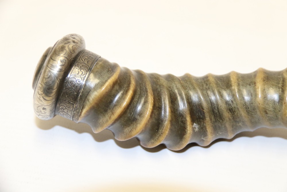 An early nineteenth-century roasting fork featuring a long, spiral horn handle with engraved silver mounts and a two-pronged steel tip. View XIV
