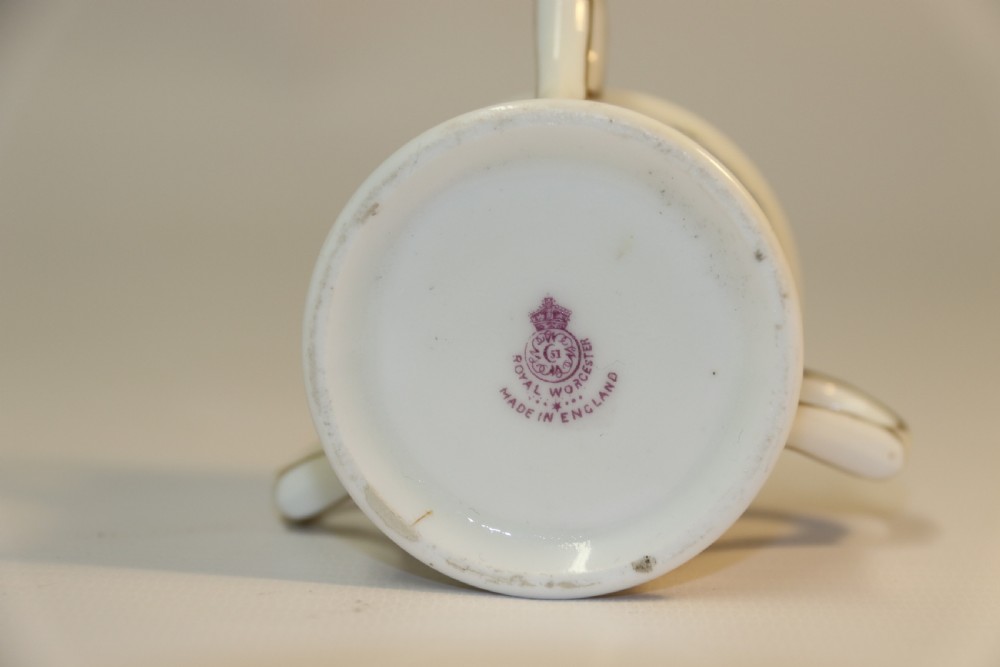 A white miniature porcelain loving cup featuring twin gilded scroll handles and a hand-painted blue floral spray. View VI