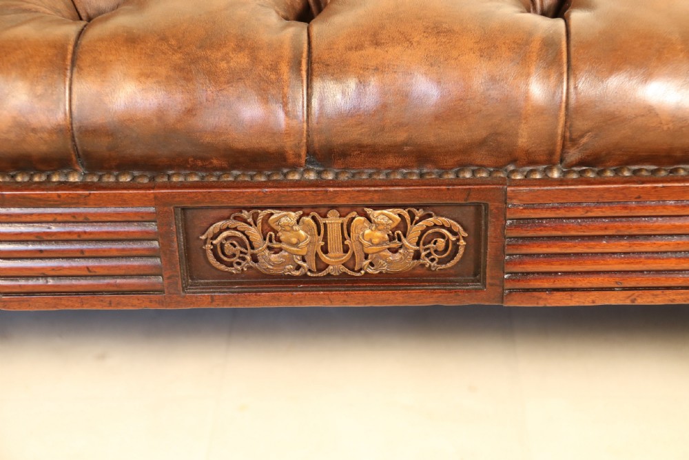 A splendid Regency mahogany and brass mounted deep buttoned leather upholstered chaise lounge View II