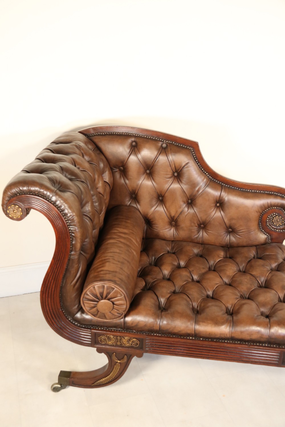 A splendid Regency mahogany and brass mounted deep buttoned leather upholstered chaise lounge View X