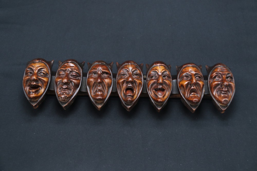 A superb Black Forest spoon rack carved in the devilish faces of the seven deadly sins. View III