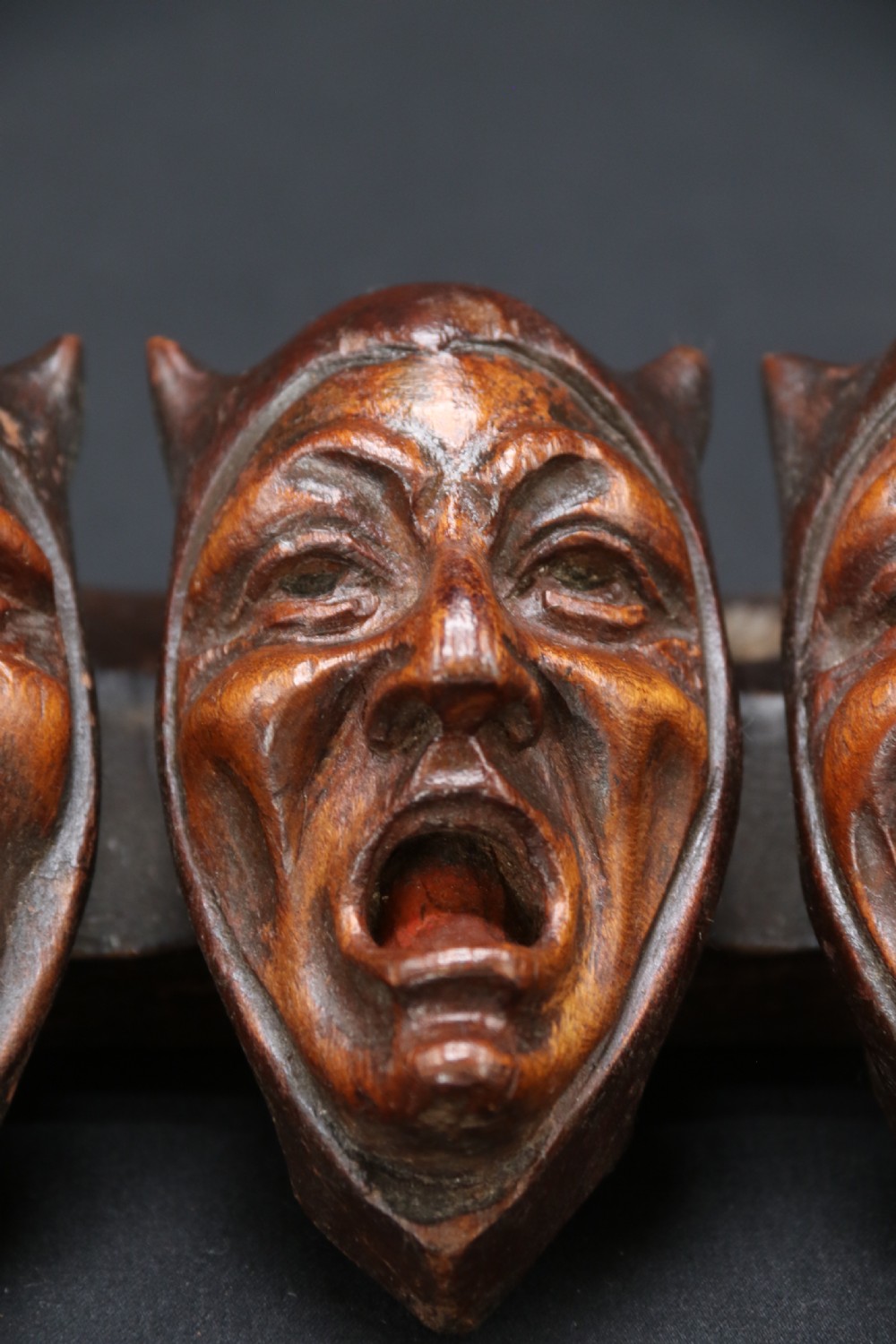 A superb Black Forest spoon rack carved in the devilish faces of the seven deadly sins. View IV