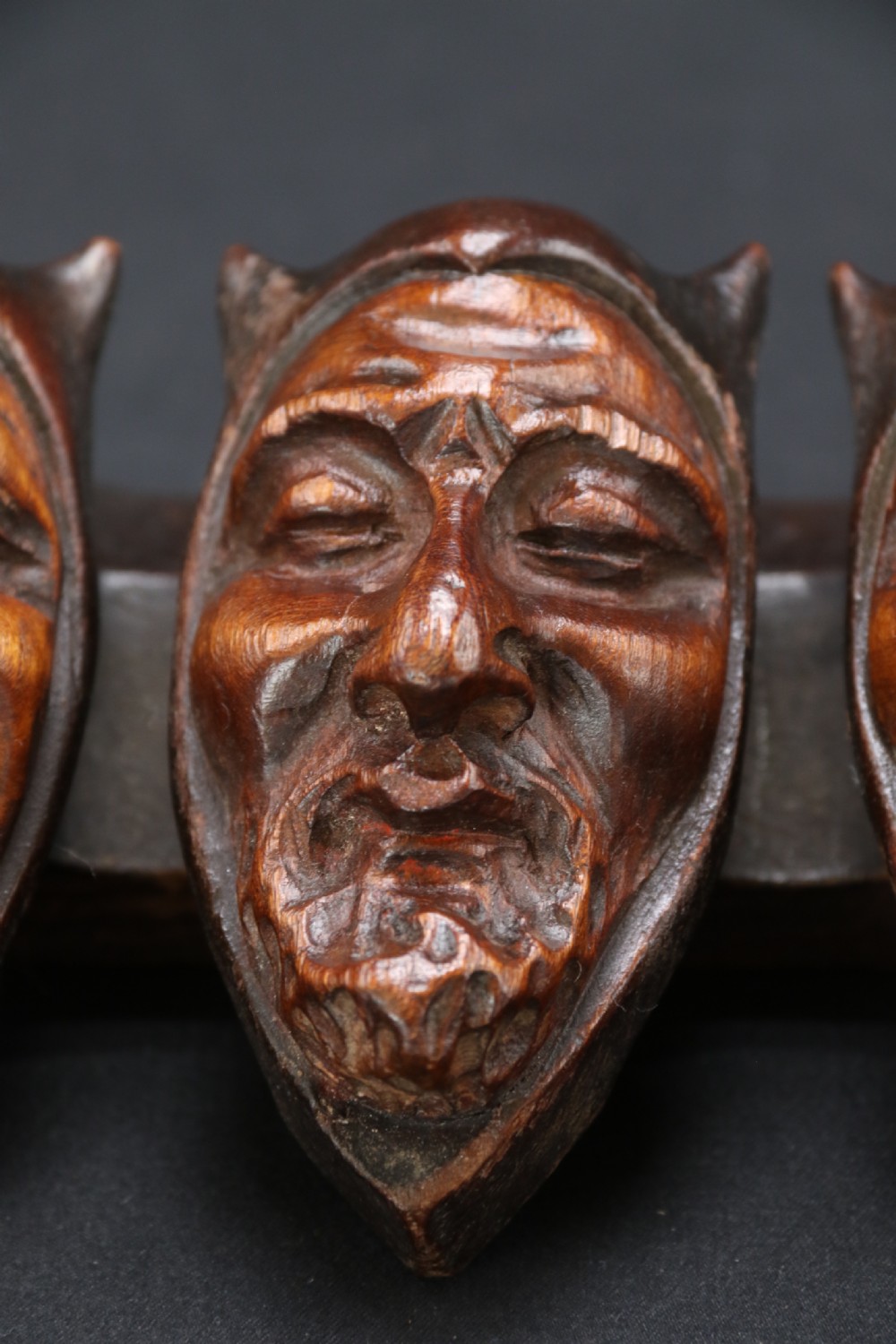 A superb Black Forest spoon rack carved in the devilish faces of the seven deadly sins. View VI