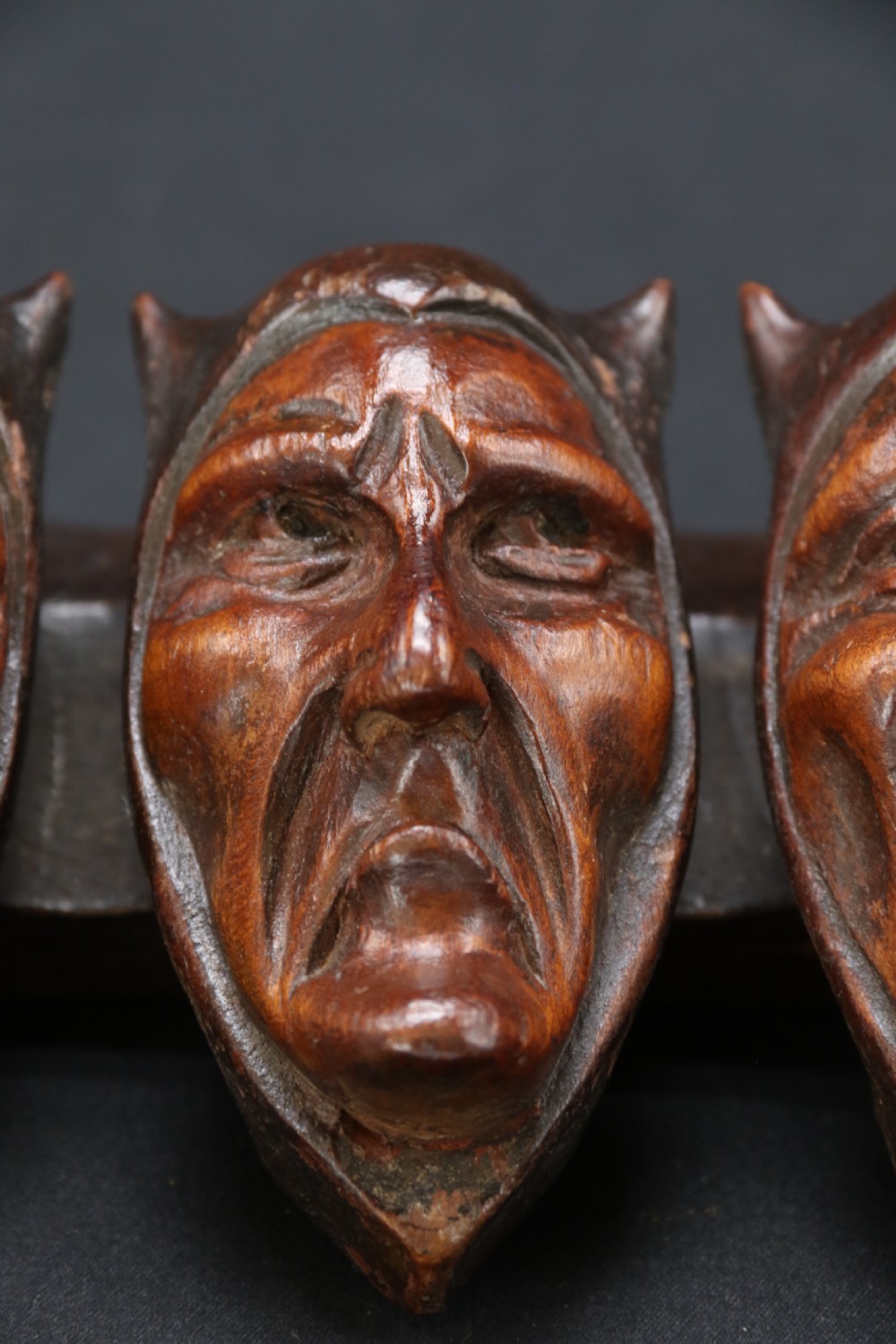 A superb Black Forest spoon rack carved in the devilish faces of the seven deadly sins. View VII