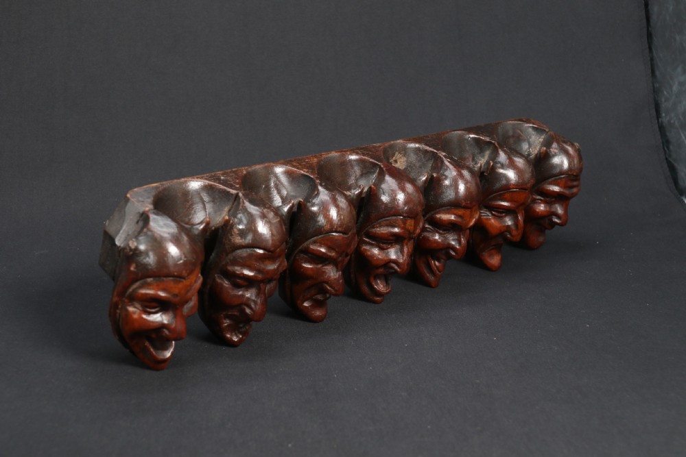 A superb Black Forest spoon rack carved in the devilish faces of the seven deadly sins. View XII