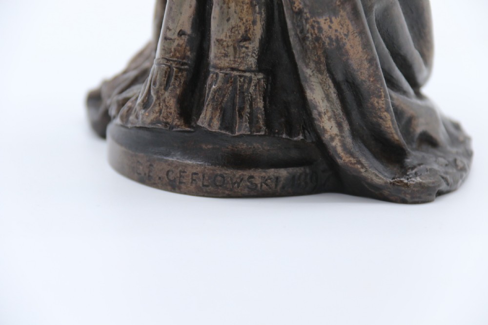 A dark patinated bronze statuette depicting Queen Victoria standing in full ceremonial robes, wearing a crown and holding a sceptre and orb. View XV