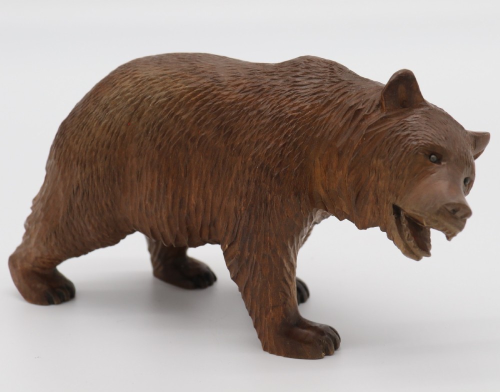 A Swiss Black Forest carved lime wood study of a prowling bear