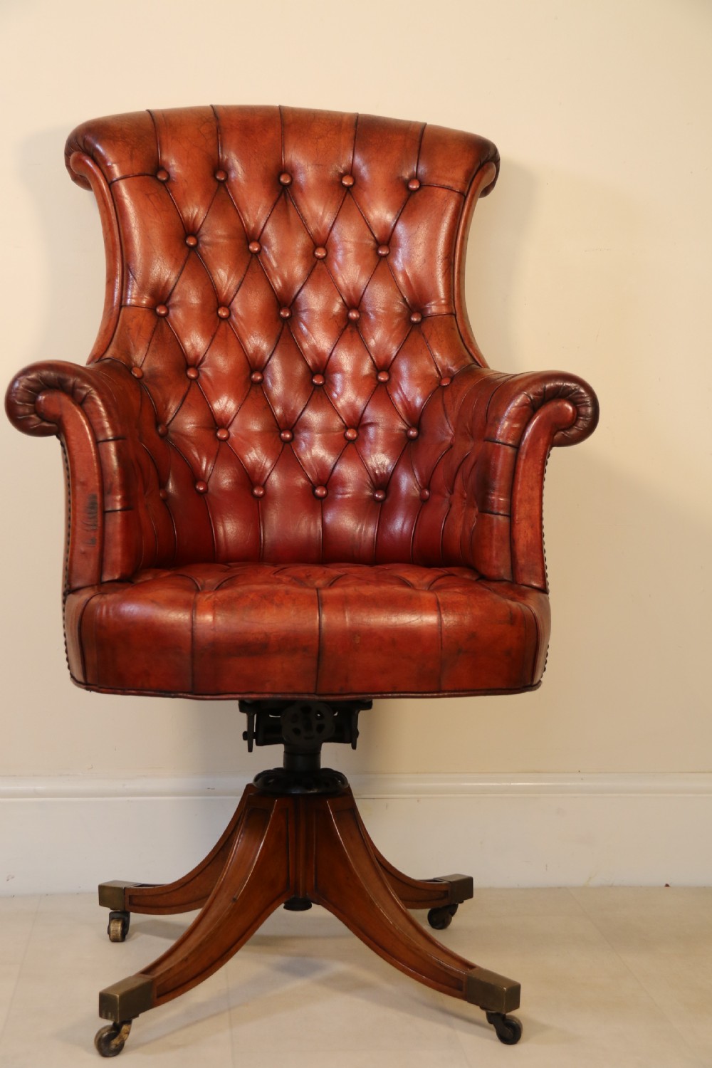 A fully adjustable early 20th C deep buttoned leather upholstered desk chair View II