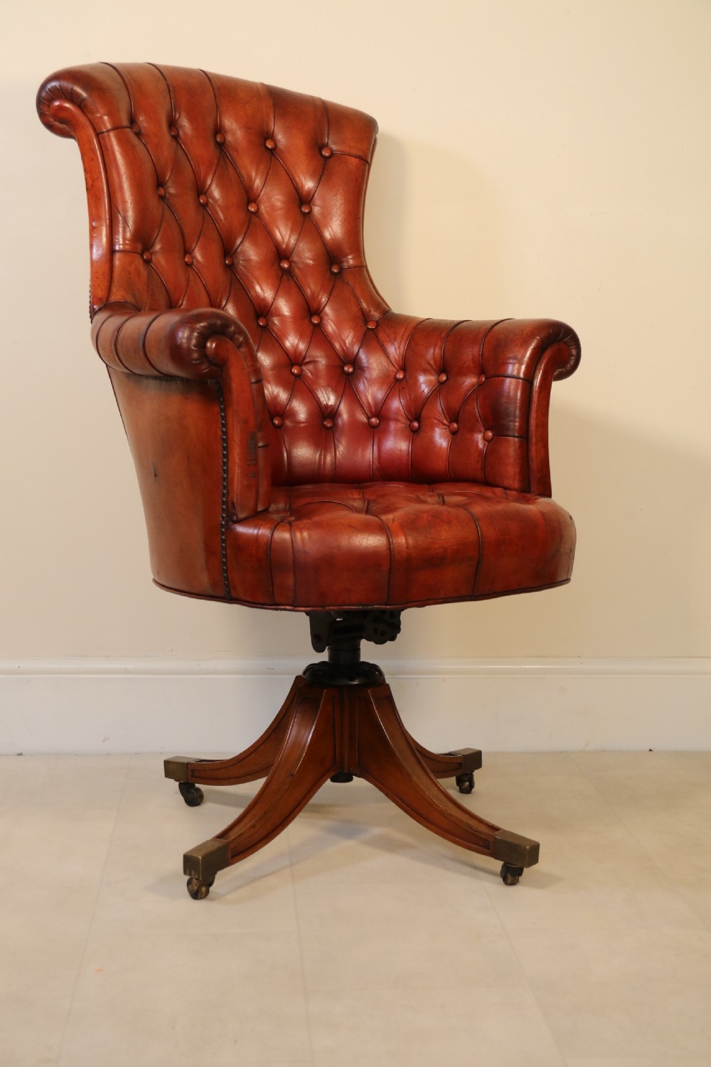 A fully adjustable early 20th C deep buttoned leather upholstered desk chair View III