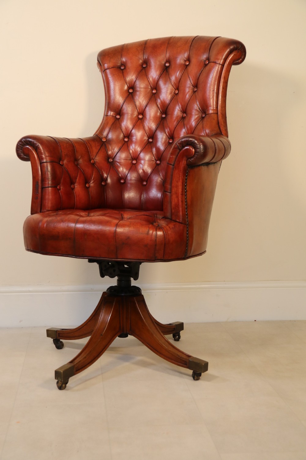 A fully adjustable early 20th C deep buttoned leather upholstered desk chair View IV