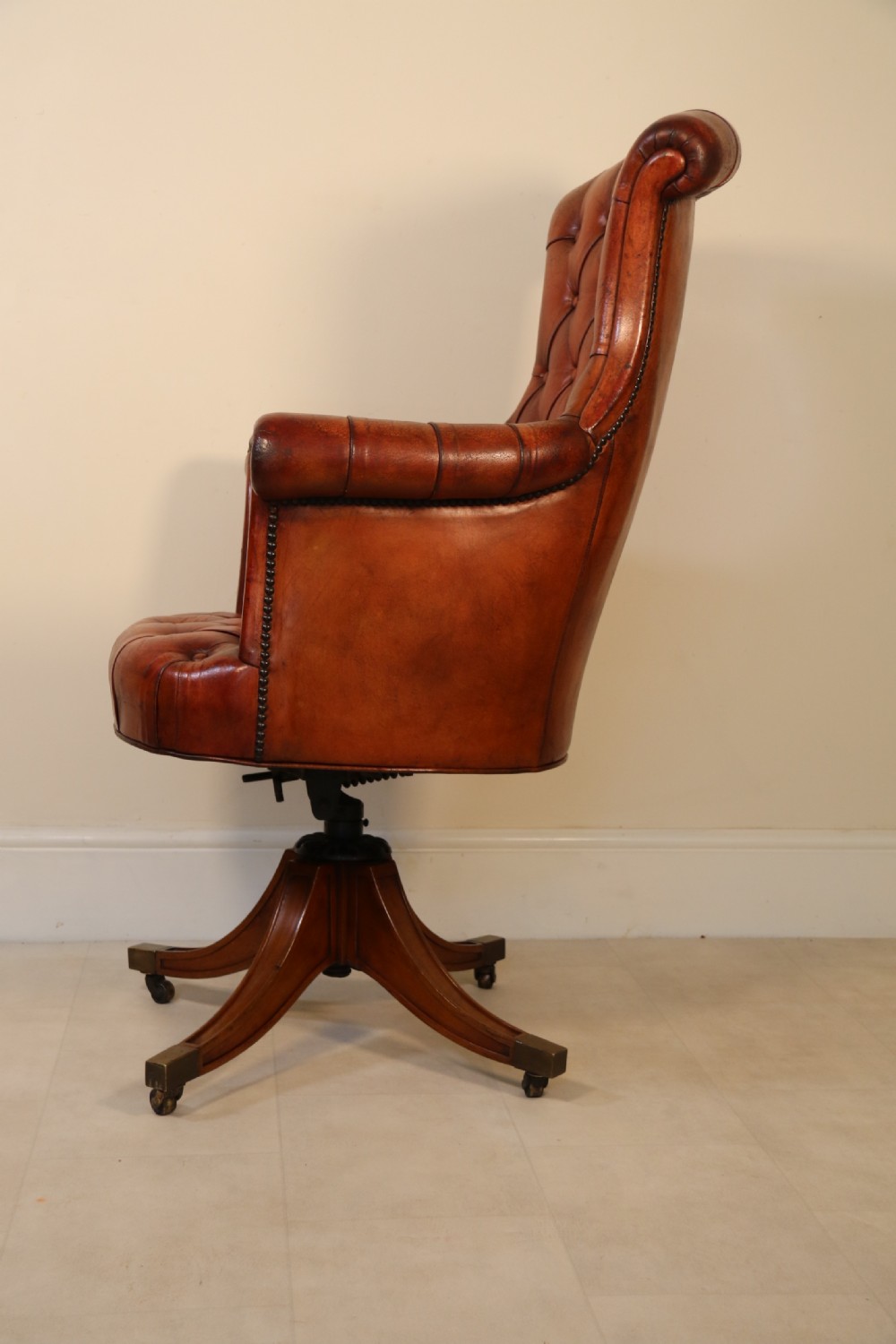 A fully adjustable early 20th C deep buttoned leather upholstered desk chair View V