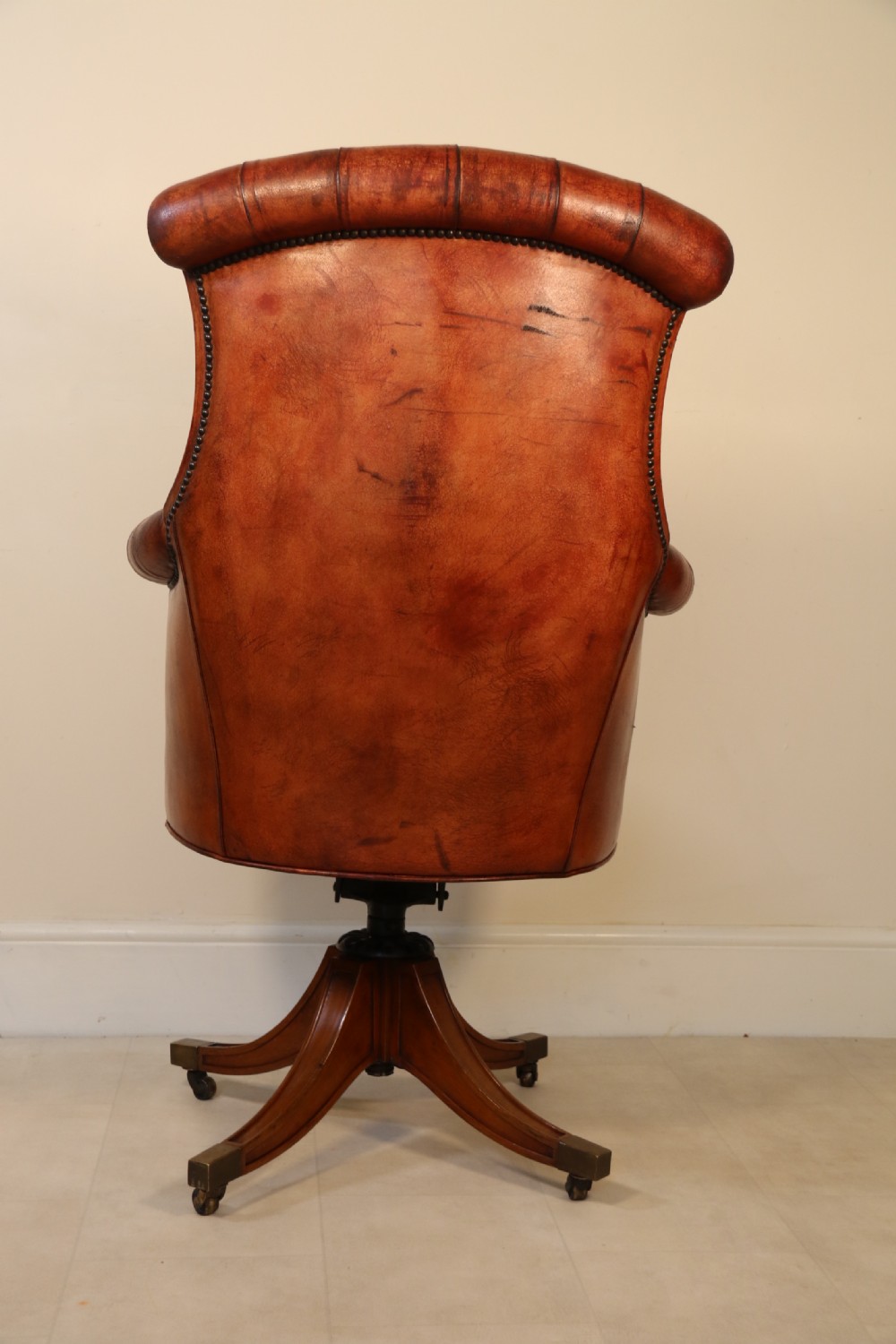 A fully adjustable early 20th C deep buttoned leather upholstered desk chair View VI