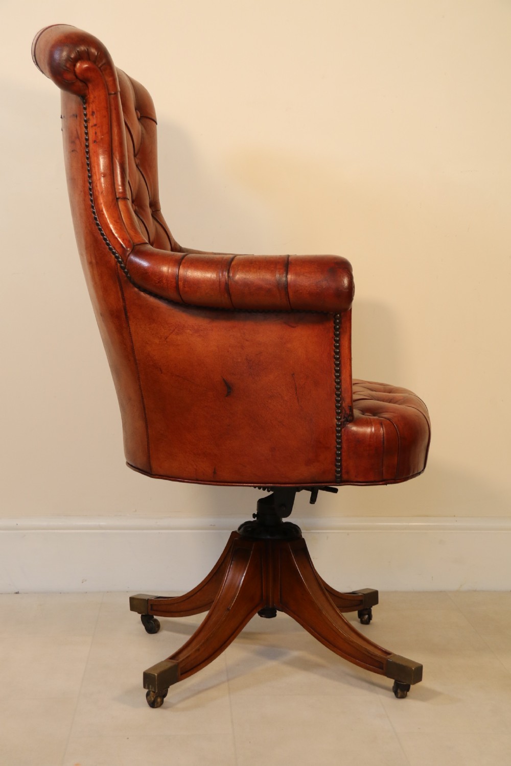 A fully adjustable early 20th C deep buttoned leather upholstered desk chair View VII