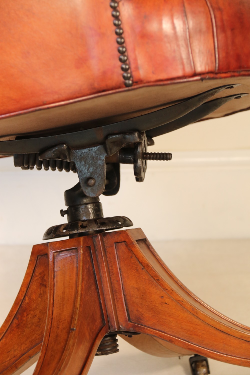 A fully adjustable early 20th C deep buttoned leather upholstered desk chair View IX