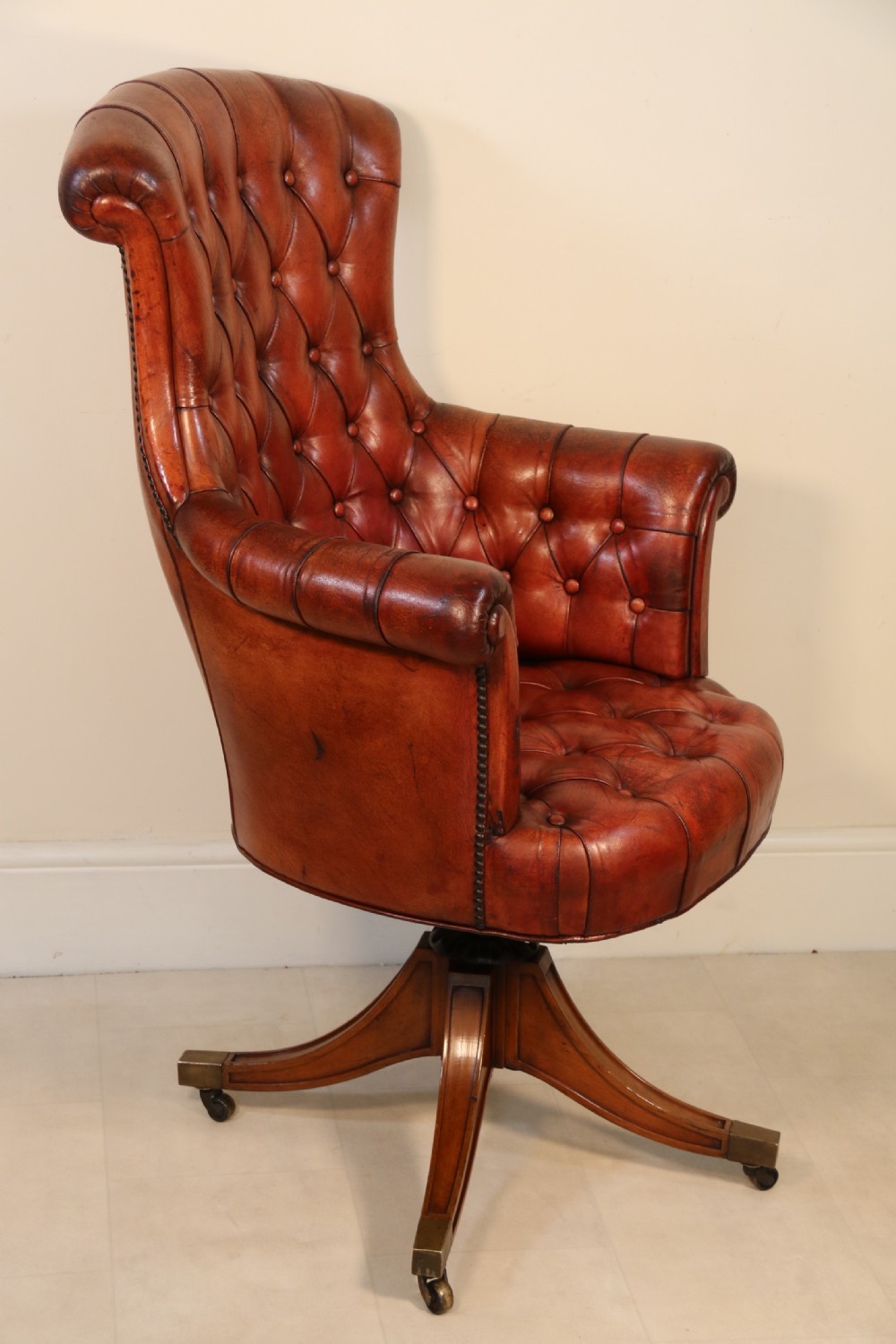 A fully adjustable early 20th C deep buttoned leather upholstered desk chair View XVI