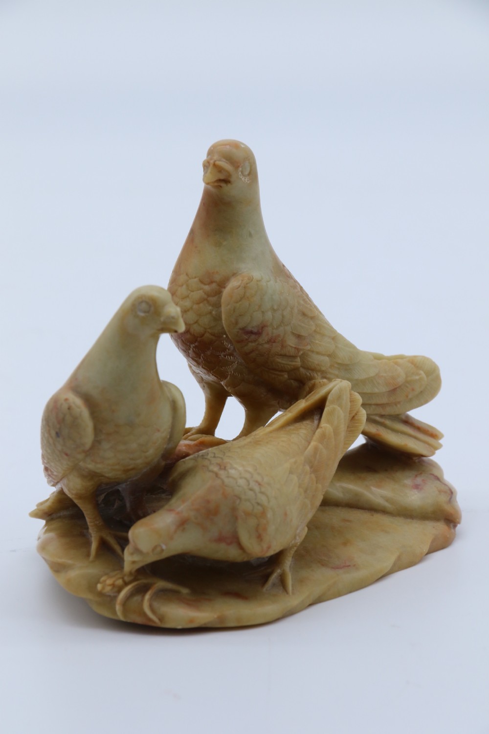A superb 19th century Chinese soapstone carved figure group of three pigeons