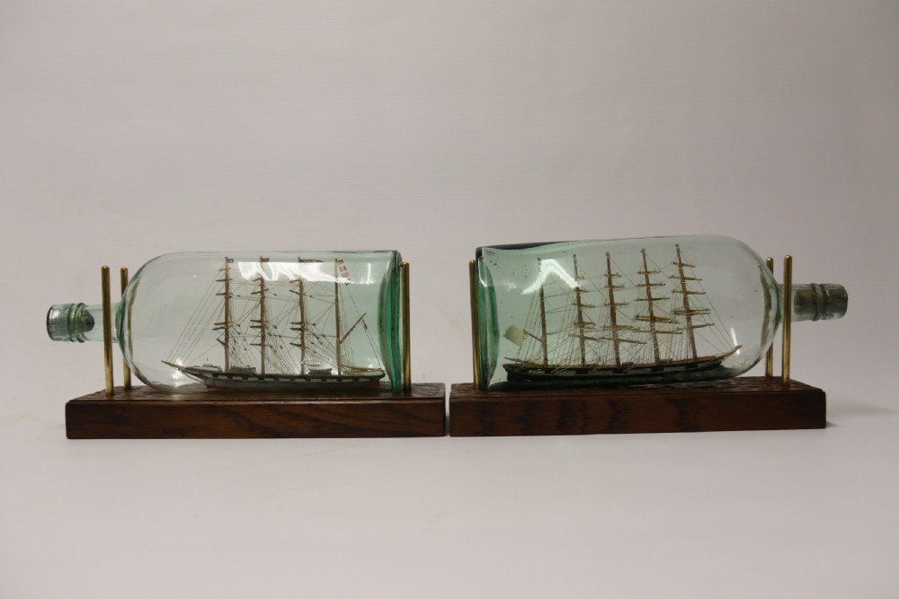 A rare pair of early 20th century model sailing ships in bottles displayed on wooden stands View III
