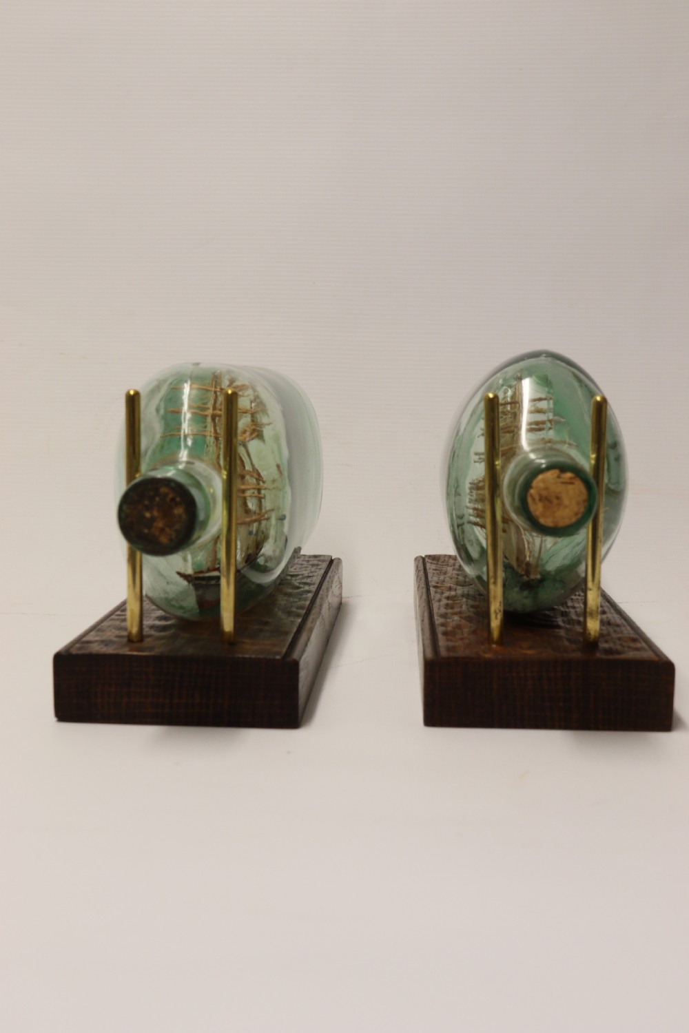 A rare pair of early 20th century model sailing ships in bottles displayed on wooden stands View IV