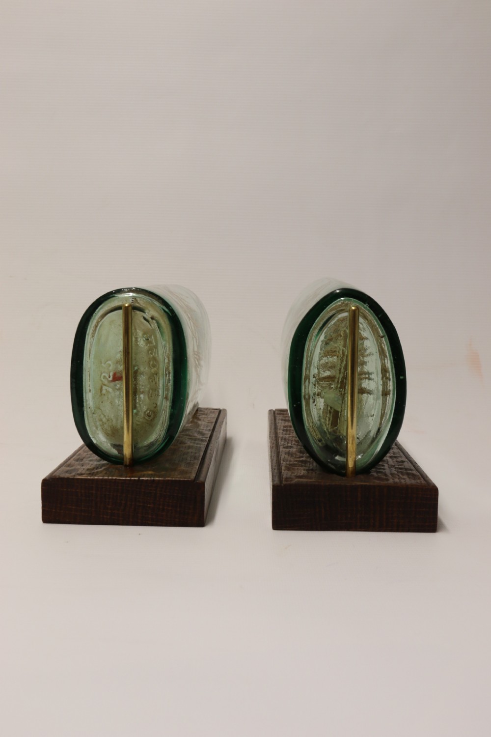 A rare pair of early 20th century model sailing ships in bottles displayed on wooden stands View V