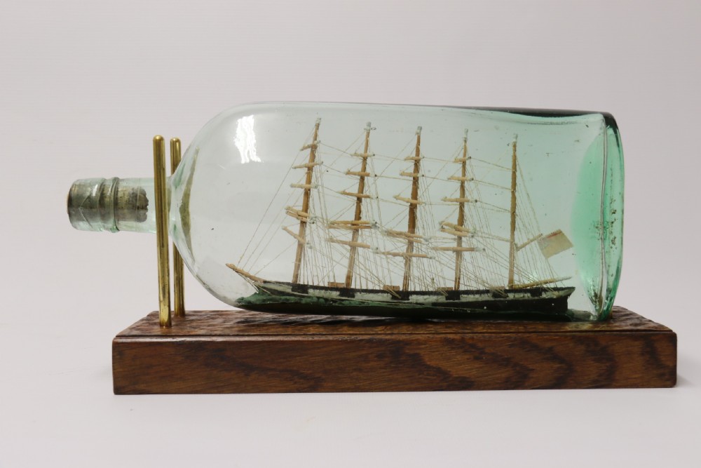 A rare pair of early 20th century model sailing ships in bottles displayed on wooden stands View VI