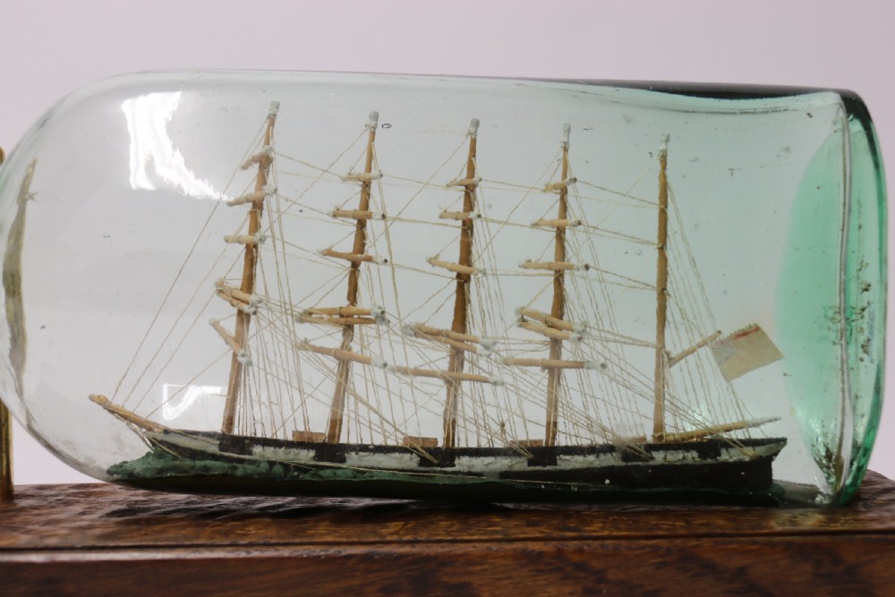 A rare pair of early 20th century model sailing ships in bottles displayed on wooden stands View VII