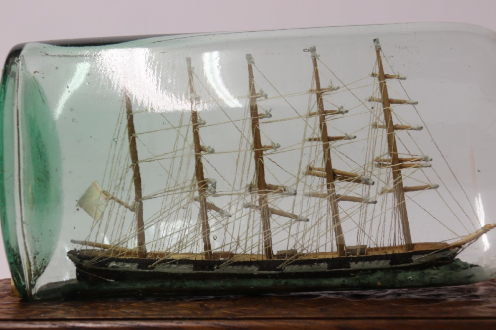 A rare pair of early 20th century model sailing ships in bottles displayed on wooden stands View VIII