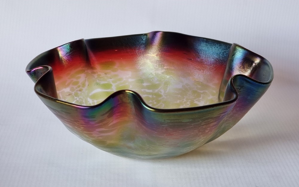 A hand-blown glass bowl featuring an undulating ruffled rim and a shimmering iridescent finish in shades of green, purple, and red. View II