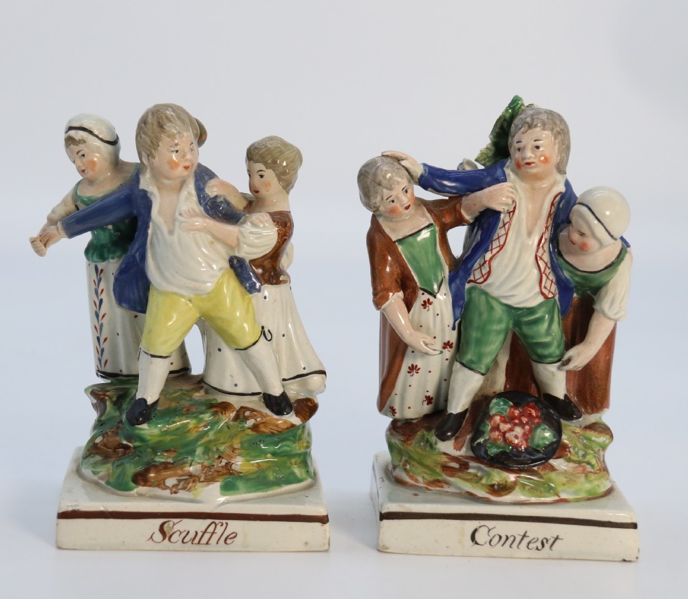 A rare pair of late 18th century English Staffordshire figure groups of two young men about to have a scuffle.
