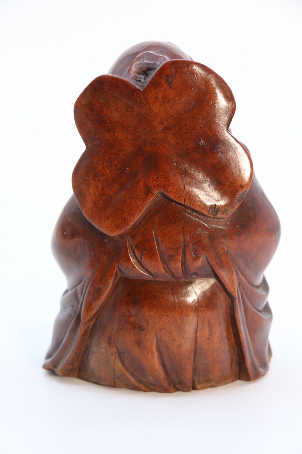 A fine Japanese carved hardwood mid 19th century Okimono of a seated man holding a bat. View VI