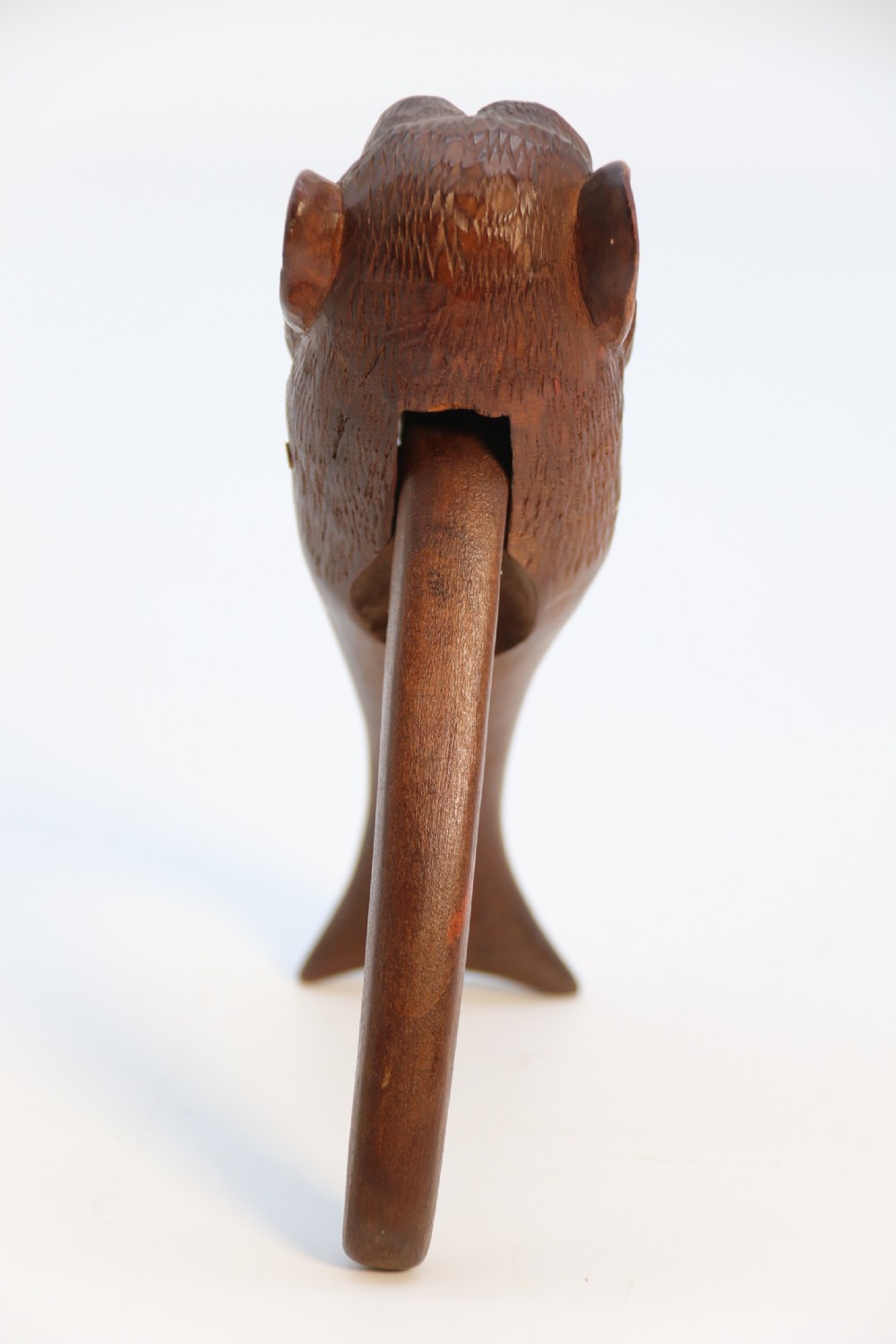 A hand-carved walnut nutcracker shaped as a monkey head with glass bead eyes and a hinged jaw mechanism. View IV