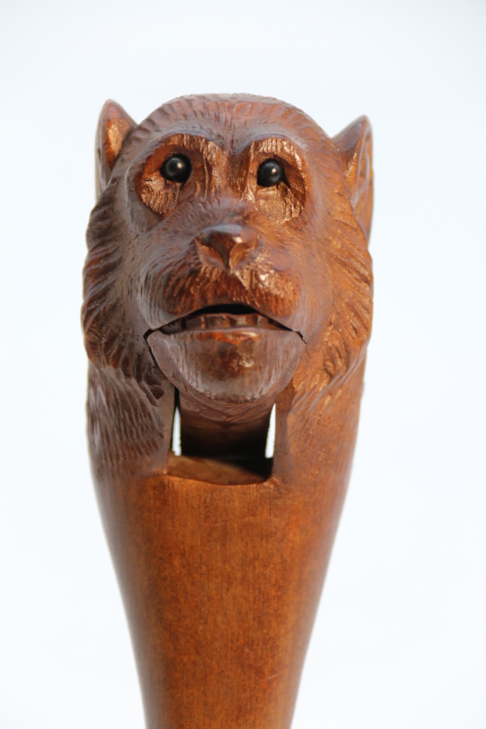 A hand-carved walnut nutcracker shaped as a monkey head with glass bead eyes and a hinged jaw mechanism. View XV