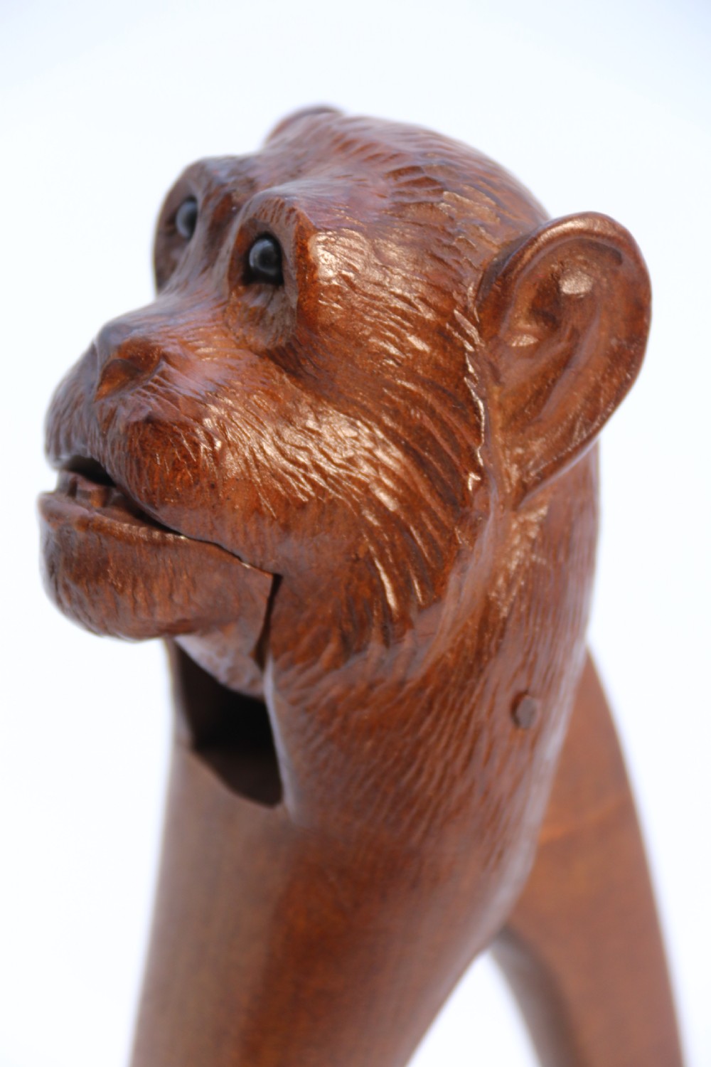 A hand-carved walnut nutcracker shaped as a monkey head with glass bead eyes and a hinged jaw mechanism. View XVII